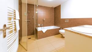 a bathroom with a tub and a toilet and a sink at Michels Villa Nordsee in Norderney