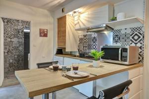 a kitchen with a wooden table and a microwave at Le Zévi - appt T2 Saint Denis in Saint-Denis