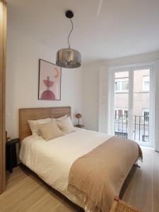a bedroom with a large bed and a pendant light at Luxury flat next to Gran Via Madrid in Madrid
