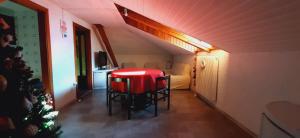 une pièce avec une table et des chaises rouges dans une pièce dans l'établissement Ampia Mansarda a Dimaro in Val di Sole, à Monclassico 12 autres photos