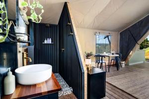 a bathroom with a white tub and a table at Cicada Luxury Camping in Kiama