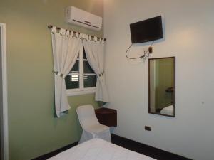 a bedroom with a bed and a mirror and a window at Hotel Selby in San Juan