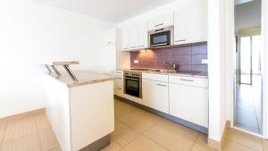 a kitchen with white cabinets and a counter top at Michels Villa Nordsee in Norderney