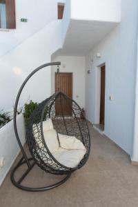 a hanging basket chair with white pillows in a hallway at Edem Garden Residence in Platis Gialos