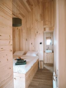 1 dormitorio con 1 cama en una pared de madera en Domaine St-Amand en Saint-Amand-de-Coly