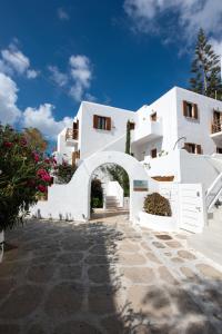 a white building with an archway in front of it at Edem Garden Residence by Estia in Platis Yialos Mykonos