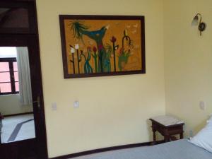1 dormitorio con una pintura en la pared en Solar do Carmo Suites & Apartments, en Salvador
