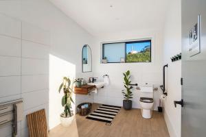 a bathroom with a toilet and a window at Cicada Luxury Camping in Kiama