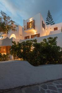 a white house with a bush in front of it at Edem Garden Residence by Estia in Platis Yialos Mykonos