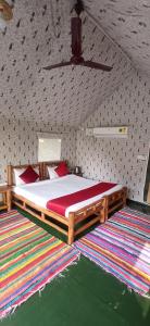 拉姆納格爾的住宿－Corbett Nature Retreat，一间卧室配有一张带红色枕头的木床。