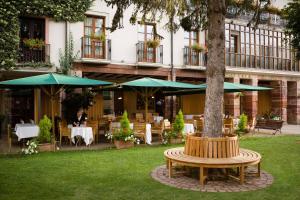 エスカライにあるエタウレン オテル ガストロノミコの木とテーブルと傘のあるパティオ