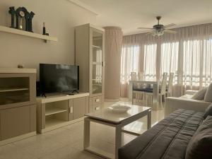 a living room with a couch and a television at Domo 5E Holiday apt with pool in Benidorm