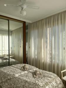 una camera con un grande letto e uno specchio di Domo 5E Holiday apt with pool a Benidorm