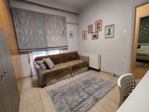 a living room with a brown couch and a rug at Estrela Comfortable Home in Volos