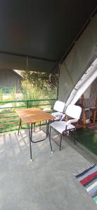 a picnic table and chairs under a tent at Corbett Nature Retreat in Rāmnagar