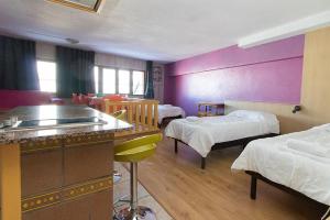 una camera d'albergo con due letti e un bar in esso di Apartaments Turistics Natural Suites Manzano 3000 a Pas de la Casa