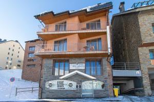 a large brick building with a balcony on it at Apartaments Turistics Natural Suites Manzano 3000 in Pas de la Casa