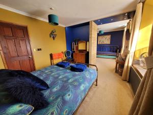 1 dormitorio con cama con colcha de pavo real en Hideaway Escapes, Farmhouse B&B & Holiday Home, Ideal family stay or Romantic break, Friendly animals on our smallholding in beautiful Pembrokeshire setting close to Narberth, en Narberth