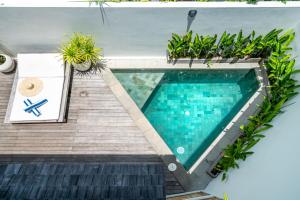 an overhead view of a swimming pool with plants at Yume Villas in Uluwatu +55 photos