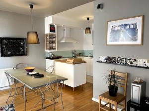 普里什蒂纳Artist's Apartment in Prishtina的配有桌椅的厨房和客厅