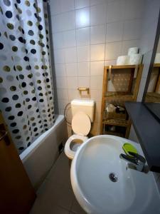 La salle de bains est pourvue de toilettes blanches et d'un lavabo. dans l'établissement Artist's Apartment in Prishtina, à Pristina