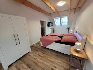 1 dormitorio con 1 cama grande con almohadas rojas en Ferienwohnungen Villa Ventil en Feldberg