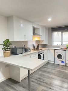 a kitchen with white cabinets and a counter top at BEA Elcot Close in Manchester