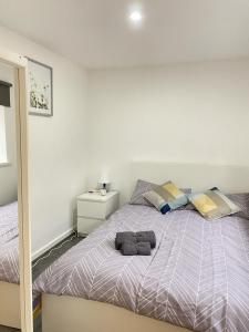 una camera da letto con un grande letto con lenzuola e cuscini viola di BEA Elcot Close a Manchester