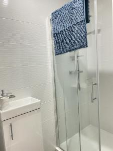 a white bathroom with a shower and a sink at BEA Elcot Close in Manchester