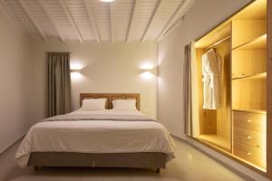 a bedroom with a large bed and a closet at Edem Garden Residence by Estia in Platis Yialos Mykonos