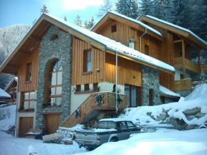 una casa con un coche aparcado en la nieve en Chalet Deleglise 1, en Valfréjus