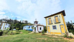 a group of houses with a church in a field at Recanto Bom Despacho in Tiradentes