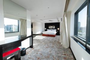 リヤドにあるMira Business Hotelのベッドと大きな窓が備わるホテルルームです。