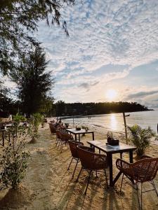 un gruppo di tavoli e sedie sulla spiaggia di Crystal Bali Style a Salad Beach