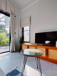 uma sala de estar com uma mesa e uma televisão em Crystal Bali Style em Salad Beach