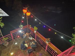 grupa ludzi siedzących w nocy na pokładzie w obiekcie Cornflower Homestay PHONG NHA w mieście Phong Nha