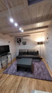 uma sala de estar com um sofá e uma mesa em Apartamenty EverySky - Domek Koło Karpacza em Myslakowice