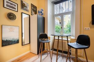 a room with two stools and a window at A27- Boutique Apartments, Best Location. By BQA in Budapest
