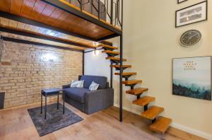 uma sala de estar com um sofá e uma escada em espiral em A27- Boutique Apartments, Best Location. By BQA em Budapeste