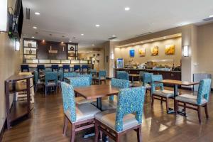a restaurant with tables and chairs and a bar at Comfort Suites Lake Norman - Huntersville in Huntersville