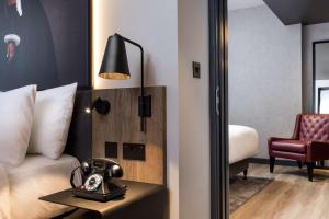 a hotel room with a bed and a phone on a table at Radisson RED Hotel, Liverpool in Liverpool
