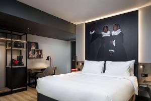a hotel room with a large bed with a large poster on the wall at Radisson RED Hotel, Liverpool in Liverpool
