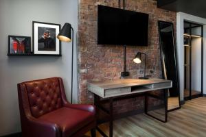 a room with a desk and a chair and a television at Radisson RED Hotel, Liverpool in Liverpool
