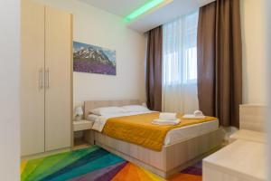 1 dormitorio con 1 cama con alfombra de arco iris en Hotel Omni, en Valjevo 53 fotos más