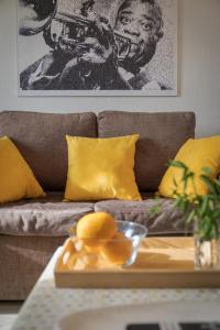 a living room with a brown couch with yellow pillows at Melody House of Ponta do Sol by HR Madeira in Ponta do Sol