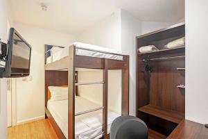 a small room with bunk beds and a tv at Tri Hotel Balneario Camboriu in Balneário Camboriú