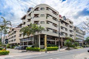 un grand bâtiment blanc dans une rue de la ville dans l'établissement Paraíso Palace Hotel II e III, à Florianópolis