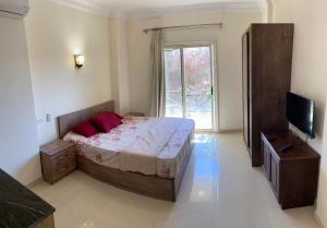 um quarto com uma cama grande e uma televisão em Bahga Palace 5 Residential Apartments em Hurghada