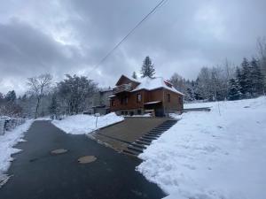 dom ze śniegiem na poboczu drogi w obiekcie Leonardo Guesthouse w Świeradowie Zdroju