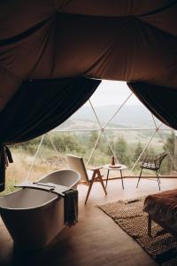 a room with a view of a tent with a table and chairs at Mandra Hills in Richka